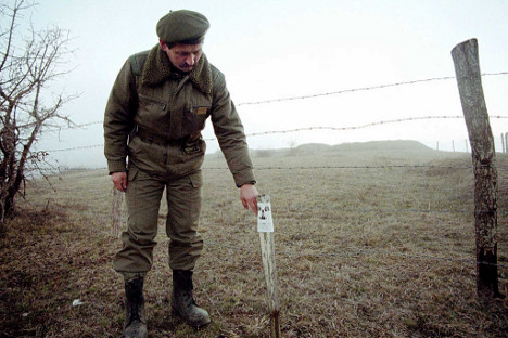 Официр Војске Југославије поред радиоактивног поља у селу Рељина код Прешева, 7. јануара 2001. Извор: Reuters.