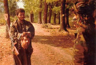 Saudi/Afghan-Arab mujahedeen holding the decapitated head of a Bosnian Serb POW who was executed and decapitated in central Bosnia in 1992.