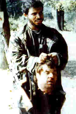 Previous photo enlarged. The head of a Serb, Blagoje Blagojevic, held by an Arab Saudi/Afghan ‘Jihad’ fighter in Crni Vrh, Bosnia, 1992.